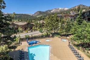 A resort with a swimming pool, lounge chairs, and mountain views. - Juniper Springs Gem with Panoramic Mountain Views! (Mammoth Lakes)