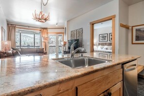 A modern kitchen with a granite countertop, stainless steel sink, and a built-in dishwasher. - Juniper Springs Gem with Panoramic Mountain Views! (Mammoth Lakes)
