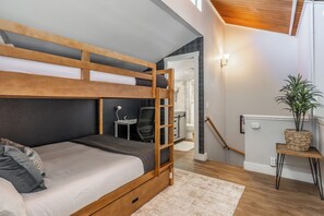 A bunk bed with a desk and chair, a small table with a plant, and a staircase leading to an upper level. - Stylish in Central Mammoth! 2 Bed / 2 Bath + Loft (Mammoth Lakes)