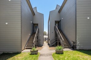 A pathway between two buildings with a central stairway leading to a door. - Stylish in Central Mammoth! 2 Bed / 2 Bath + Loft (Mammoth Lakes)