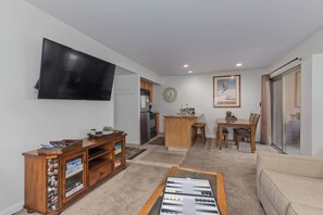Ein Wohnzimmer mit Fernseher, einer Holz-Unterhaltungsecke, Couchtisch und Sofa.