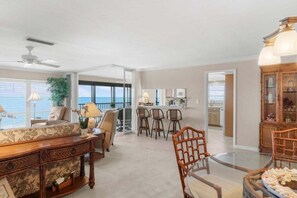 A spacious living area with a dining table, chairs, a sofa, and a view of the ocean. - Kings Crown 318 3 Bedroom Condo (Sanibel)