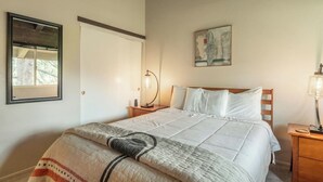 A bedroom with a bed, bedside tables, a nightstand, a mirror, and a painting on the wall. - Adventure Basecamp! 1BR + Loft Close to Village (Mammoth Lakes)