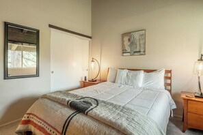 A bedroom with a bed, bedside tables, a nightstand, a mirror, and a painting on the wall. - Adventure Basecamp! 1BR + Loft Close to Village (Mammoth Lakes)
