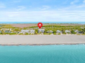 A beachfront property with a row of houses, a beach, and a clear view of the ocean. - Angel's View 4 Bedroom Home (Captiva)