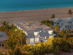 A beachfront property with multiple houses, a pool, and a beach view. - Angel's View 4 Bedroom Home (Captiva)