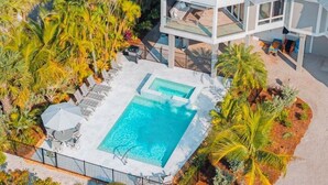 A multi-story building with a rooftop pool surrounded by palm trees. - Angel's View 4 Bedroom Home (Captiva)