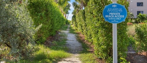 A pathway leading to a private beach access sign for Seashields of Sanibel, indicating guest-only access.