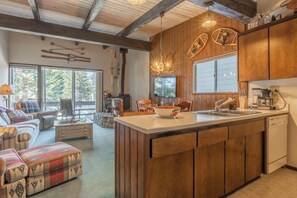 Eine moderne Küche mit Holdekor, einer Kochinsel und einem Essbereich mit Sofa und Stühlen.