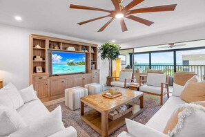 A living room with a television, wooden furniture, and a view of the ocean. - Kings Crown Unit 305 3 Bedroom Condo (Sanibel)