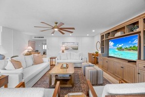 A living room with a television, sofa, coffee table, and ceiling fan. - Kings Crown Unit 305 3 Bedroom Condo (Sanibel)