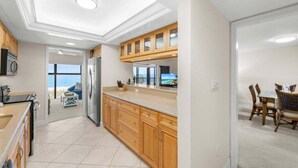 Una cocina moderna con armarios de madera, una isla grande y vistas al exterior.