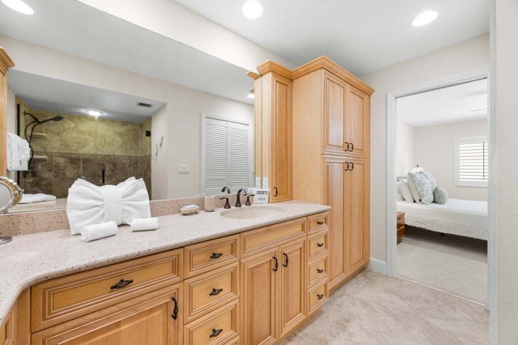 A bathroom with a large vanity, a shower, and a mirror.