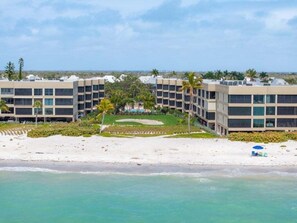 A beachfront hotel with multiple buildings, a sandy beach, and a clear view of the ocean. - Kings Crown Unit 217 2 Bedroom Condo (Sanibel)
