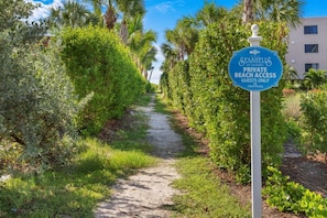 Een pad dat leidt naar een bordje voor privéstrandtoegang van Seashields of Sanibel, waarop staat dat alleen gasten toegang hebben.