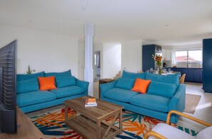 A modern living room with two blue sofas, a coffee table, and a TV. - Kaz Olivia 3 Bedroom Home (Gros Islet)