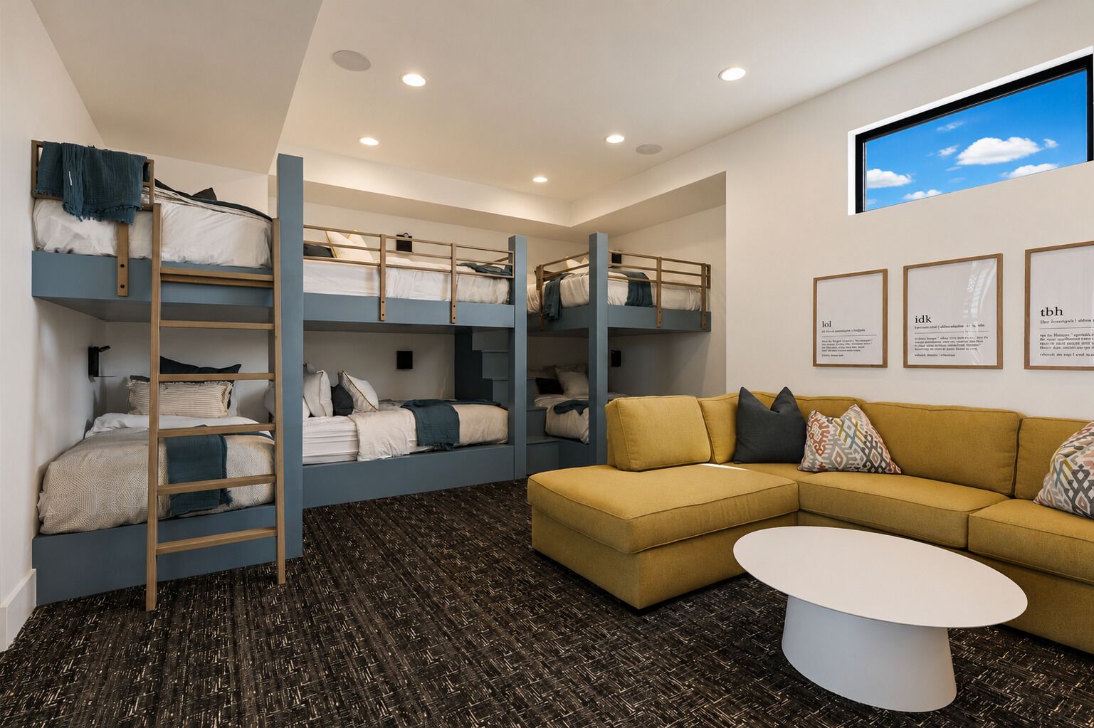 A room with bunk beds, a sofa, a coffee table, and framed informational posters on the wall.