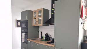 A compact kitchen with a microwave, stove, sink, and cabinets.