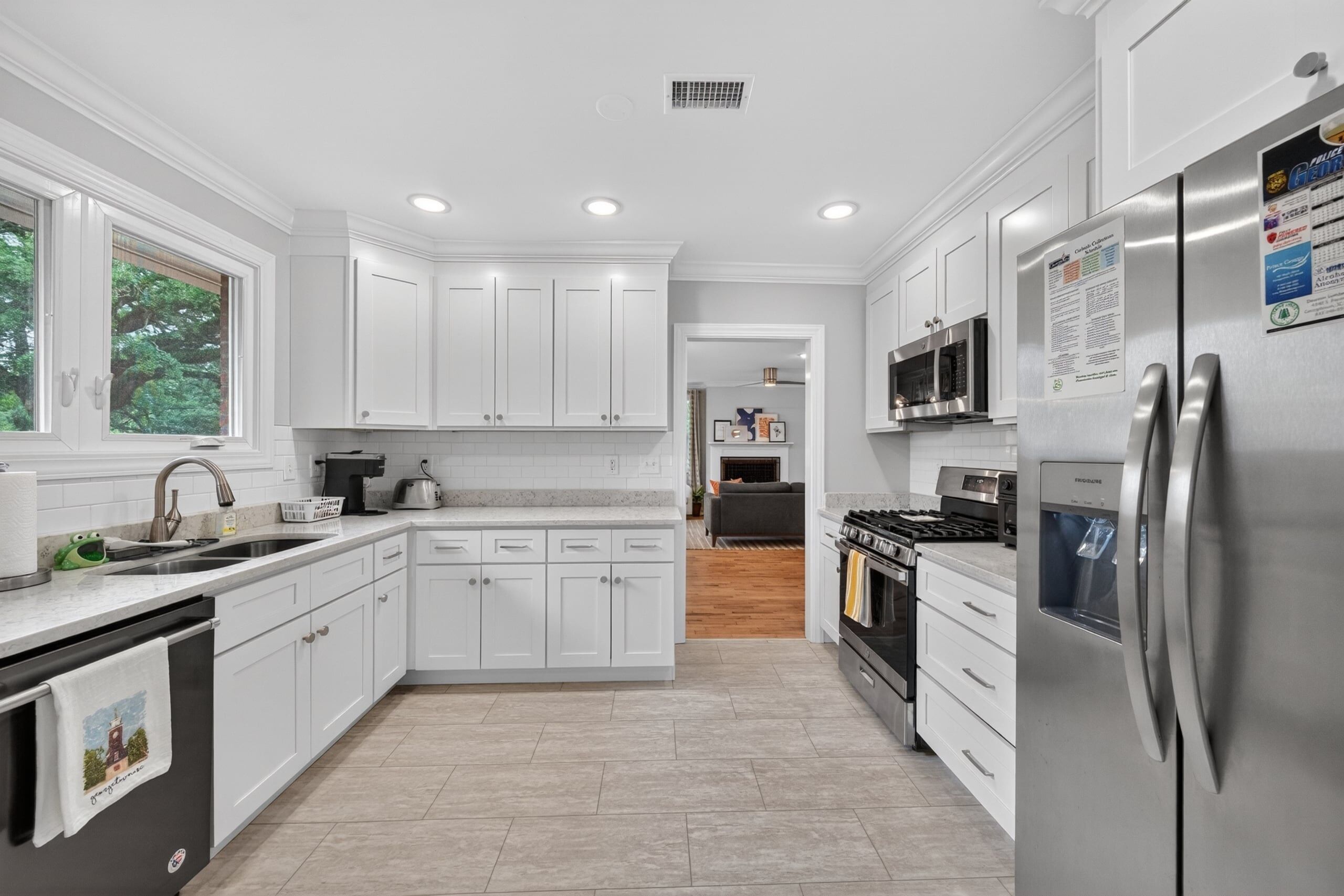 A modern kitchen with white cabinetry, stainless steel appliances, and a central island.
