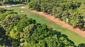 A golf course with sand bunkers, a clubhouse, and dense surrounding trees. - 127-3 Puttin On The Ritz 2 Bedroom Condo (Pawleys Island)