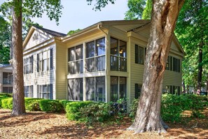A two-story house with large windows, a covered porch, and a well-maintained garden. - 127-3 Puttin On The Ritz 2 Bedroom Condo (Pawleys Island)