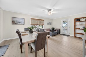 A dining area with a table, chairs, and a ceiling fan. - Charming Coastal Retreat 3 Bedroom Home (Georgetown)
