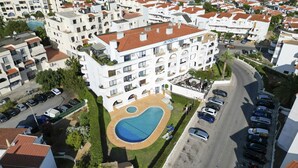 A multi-story hotel with a swimming pool and a parking area. - #412 Apartment with Pool | 1BR | Near Oura & the Beaches (Albufeira)