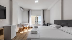 A modern hotel room with a bed, a desk, a chair, and a TV. - Sea Stay Studio Durr s Waterfront (Durrës)