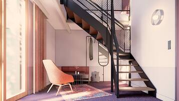 Een modern interieur met een trap, een stoel en een vloerkleed.