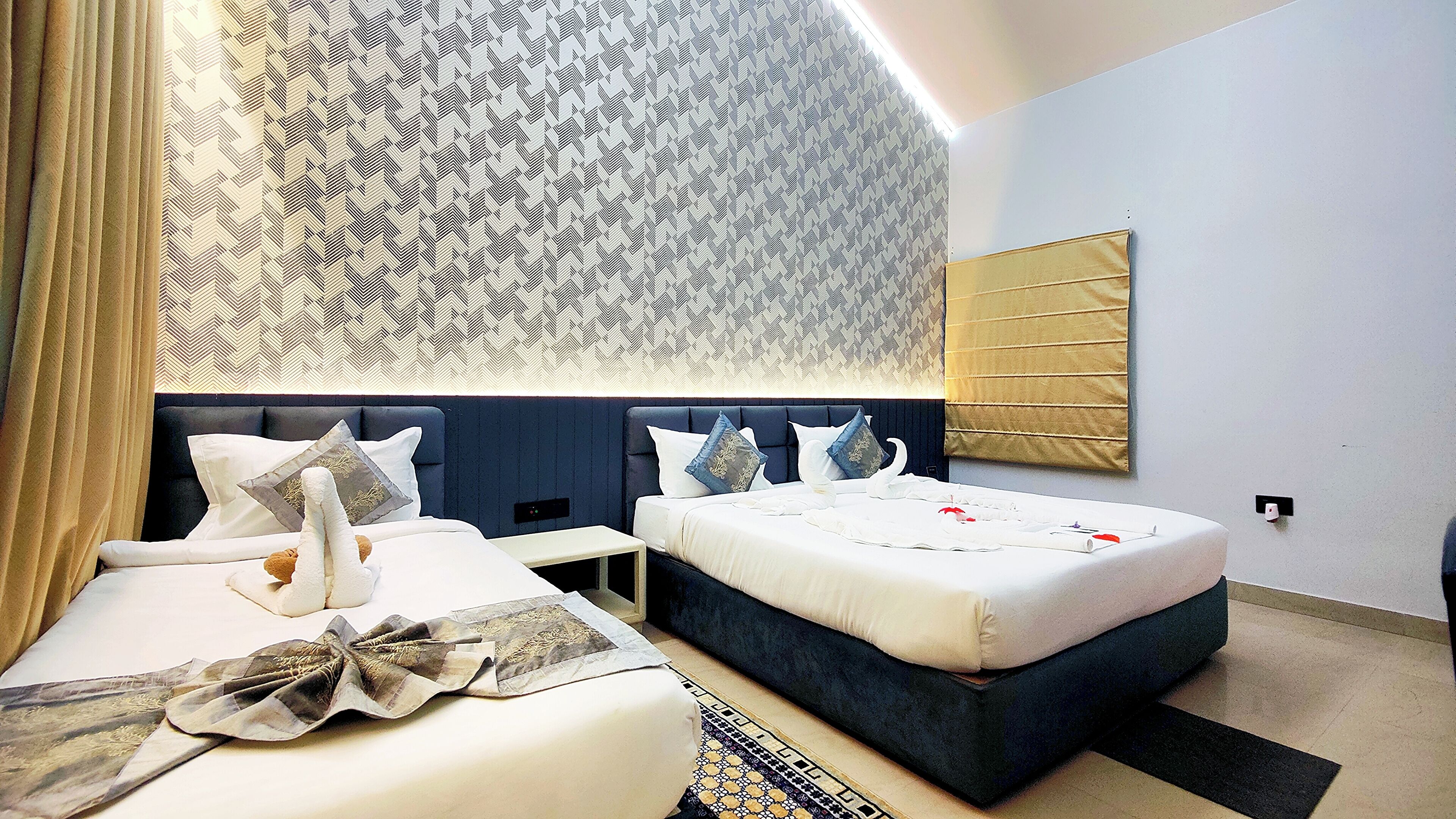 Una habitación de hotel moderna con una cama grande, una mesita de noche y un panel decorativo en la pared.
