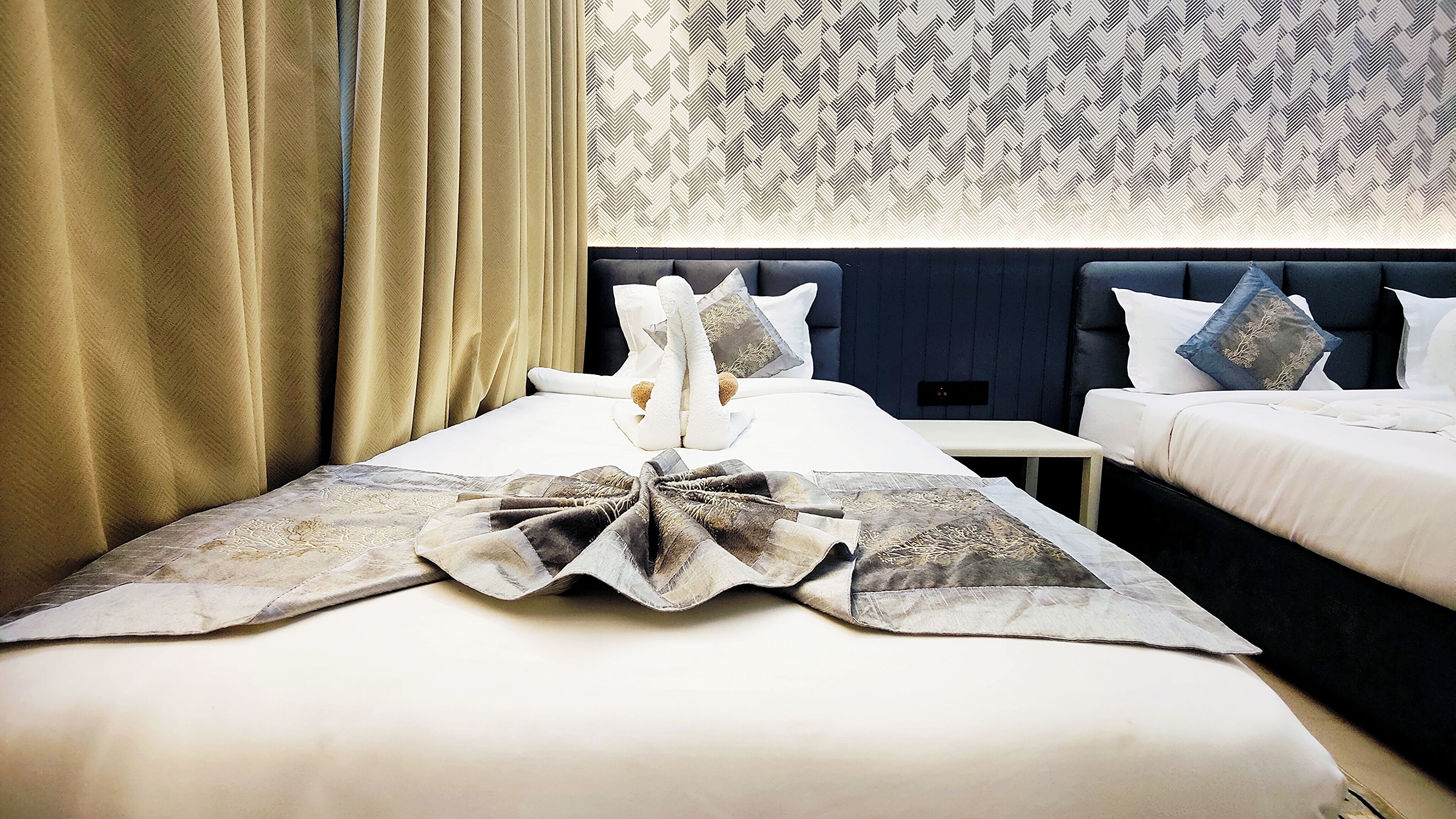 Una habitación de hotel con una cama, una mesita de noche y una mesilla.