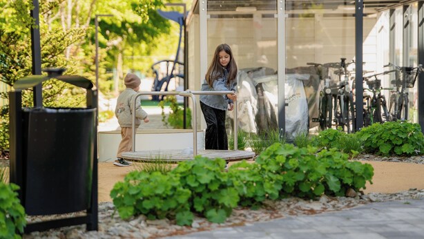 A person standing in a sheltered area with a bicycle rack in the background. - Posesja Plażowa 4c II & SPA (Grzybowo)