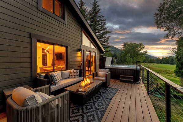 Una terraza con asientos al aire libre, un jacuzzi y vistas del paisaje.