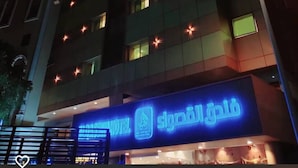Un hôtel à plusieurs étages, doté de fenêtres illuminées et d’une enseigne bien visible à l’entrée.