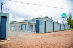 A building with a gated entrance, air conditioning units, and a satellite dish.