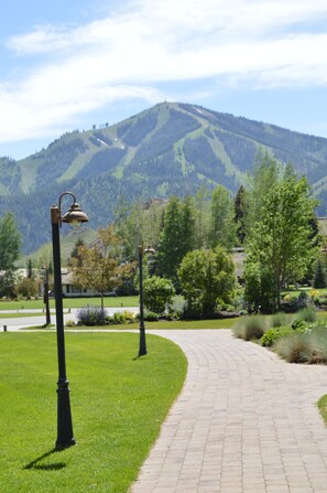 A paved pathway, green grass, and a mountain in the background. - Creekside Condo 1304 - Newly Remodeled Sun Valley Loft (Sun Valley)