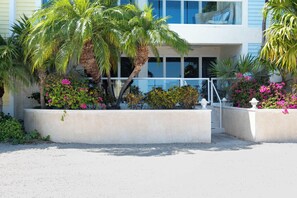 A building with a modern design, featuring a balcony with wicker furniture. - Mariners Club 116, VRNR Luxury Collection, Epic Amenities, Boat Slip Available (Key Largo)