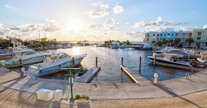 A marina with boats docked, a clear sky, and buildings in the background. - Mariners Club 116, VRNR Luxury Collection, Epic Amenities, Boat Slip Available (Key Largo)