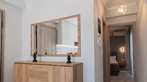 A modern bathroom with a wooden vanity, a large mirror, and marble flooring. - Ireon Luxury Suites 2 by RentalsPro - Nea Plagia Halkidiki (Nea Plagia)