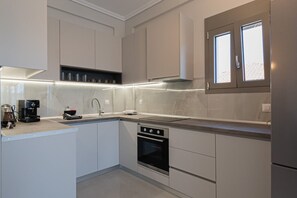 Eine moderne Küche mit weißen Schränken, einem Einbauofen und einem Fenster über der Spüle.