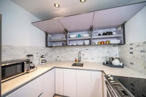 Eine moderne Küche mit Mikrowelle, Kaffeemaschine und eingebautem Backofen.