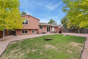 A residential backyard with a lawn, a patio table, and a barbecue grill. - Pipit Place | Pet-Friendly Home w/ Fenced Yard (Fort Collins)