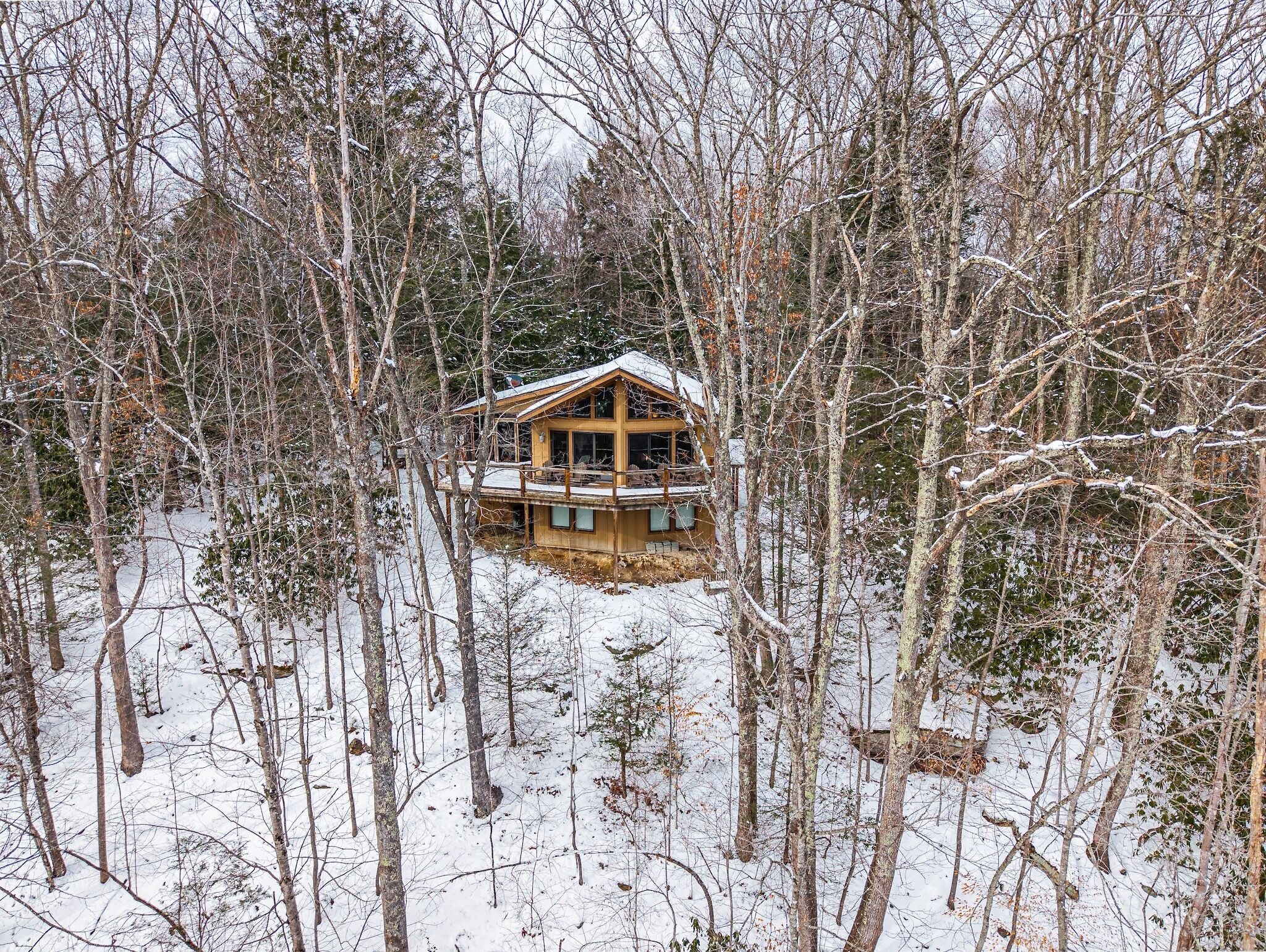 A wooden cabin surrounded by snow-covered trees.