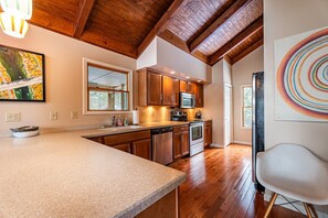 A kitchen with wooden cabinets, a microwave, and a dishwasher. - Luxury home on The Meadow River with stunning view of the river canyon (Hico)