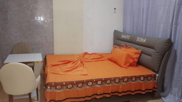 Un dormitorio con cama, escritorio y silla.