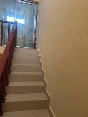 Una escalera con barandillas de madera que conduce a una puerta de cristal.
