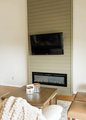 A living room with a flat-screen TV mounted above a fireplace. - Charming 4BR Lakefront Condo Getaway- Near Boat Marina and Silver Dollar City. (Branson)