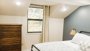 A bedroom with a bed, a dresser, a window with curtains, and a lamp. - Charming 4BR Lakefront Condo Getaway- Near Boat Marina and Silver Dollar City. (Branson)