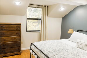 A bedroom with a bed, a dresser, a window with curtains, and a lamp. - Charming 4BR Lakefront Condo Getaway- Near Boat Marina and Silver Dollar City. (Branson)