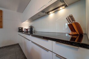 Eine moderne Küche mit schwarzem Arbeitsplatz, Edelstahlgeräten und einem Holzmesserblock.